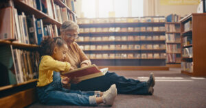 grandma and granddaughter reading in the library